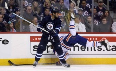 Winnipeg Jets' Dustin Byfuglien (33) hits Edmonton Oilers' Luke Gazdic (20) during second period NHL hockey action in Winnipeg, Monday, February 16, 2015. THE CANADIAN PRESS/Trevor Hagan
